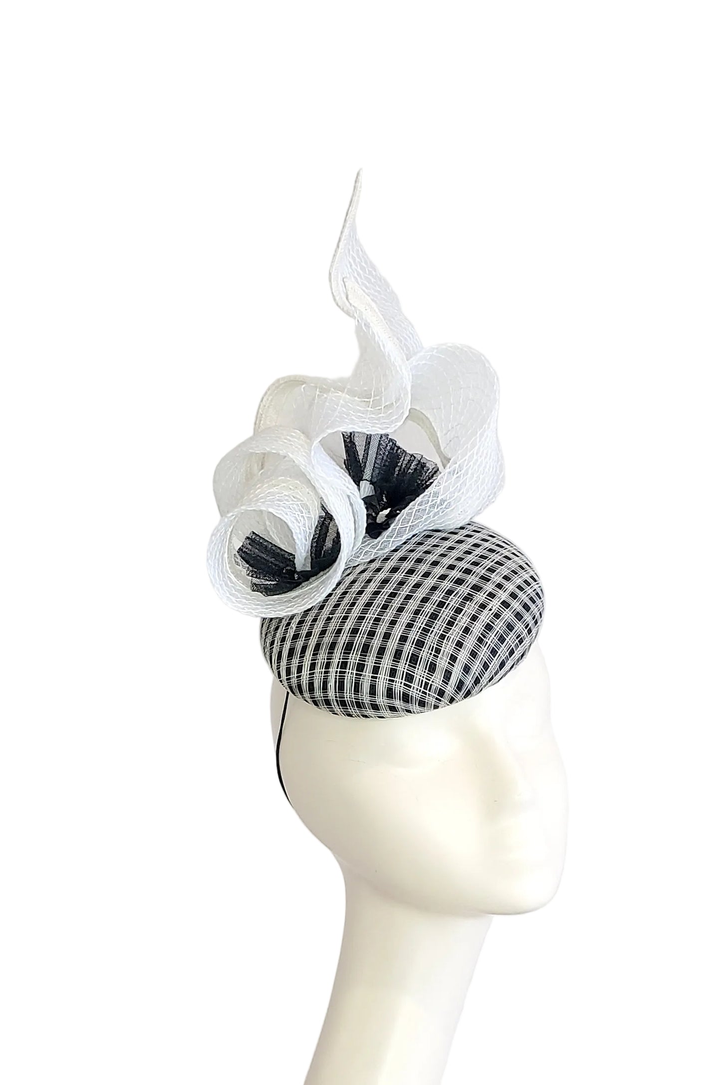 A black and white checkered fascinator hat, displayed on a white mannequin head against a white background.