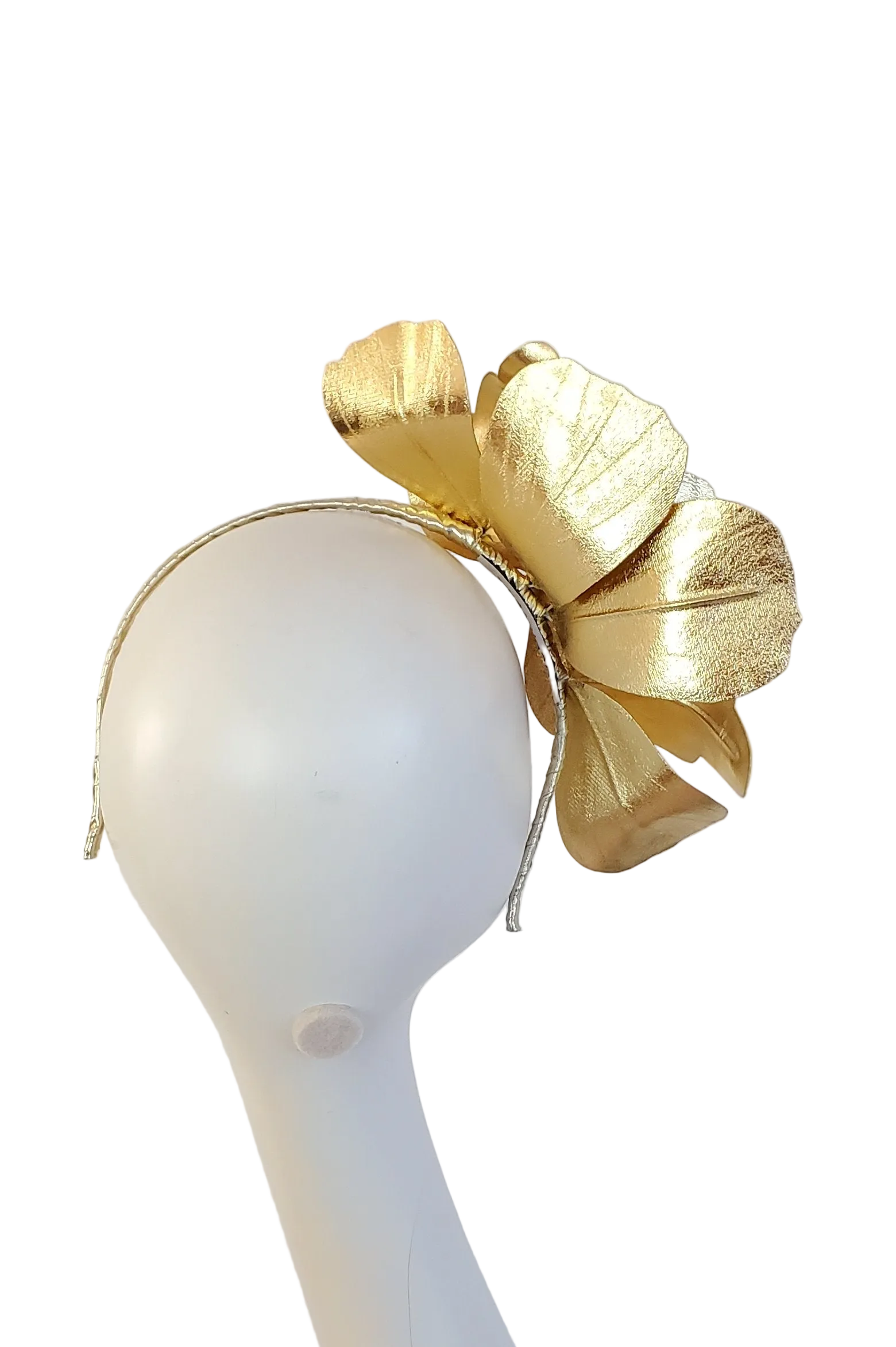 A gold metallic fascinator headpiece displayed on a white mannequin head against a white background.