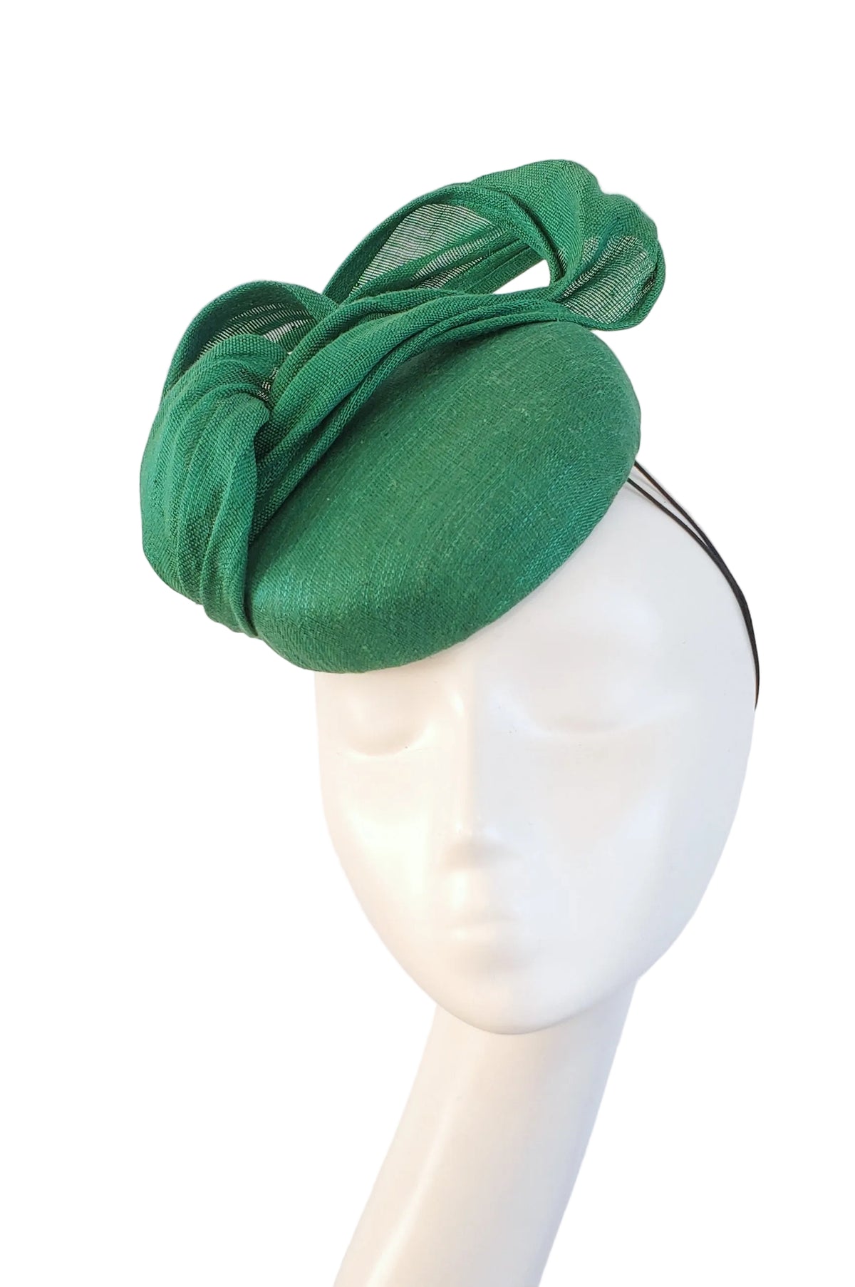 A bright green fascinator hat with a sheer mesh bow detail, displayed on a white mannequin head against a light gray background.