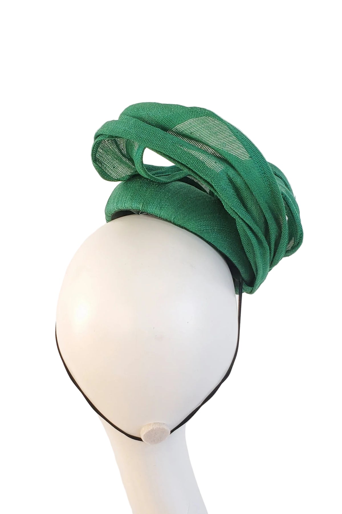 A green fascinator headpiece made of sheer mesh and gathered fabric, displayed on a white mannequin head with a black chin strap against a plain white background.